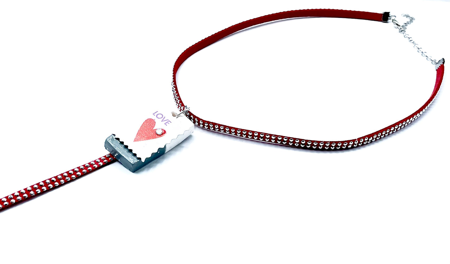 Necklace with a red cord and heart-shaped tag on a white background