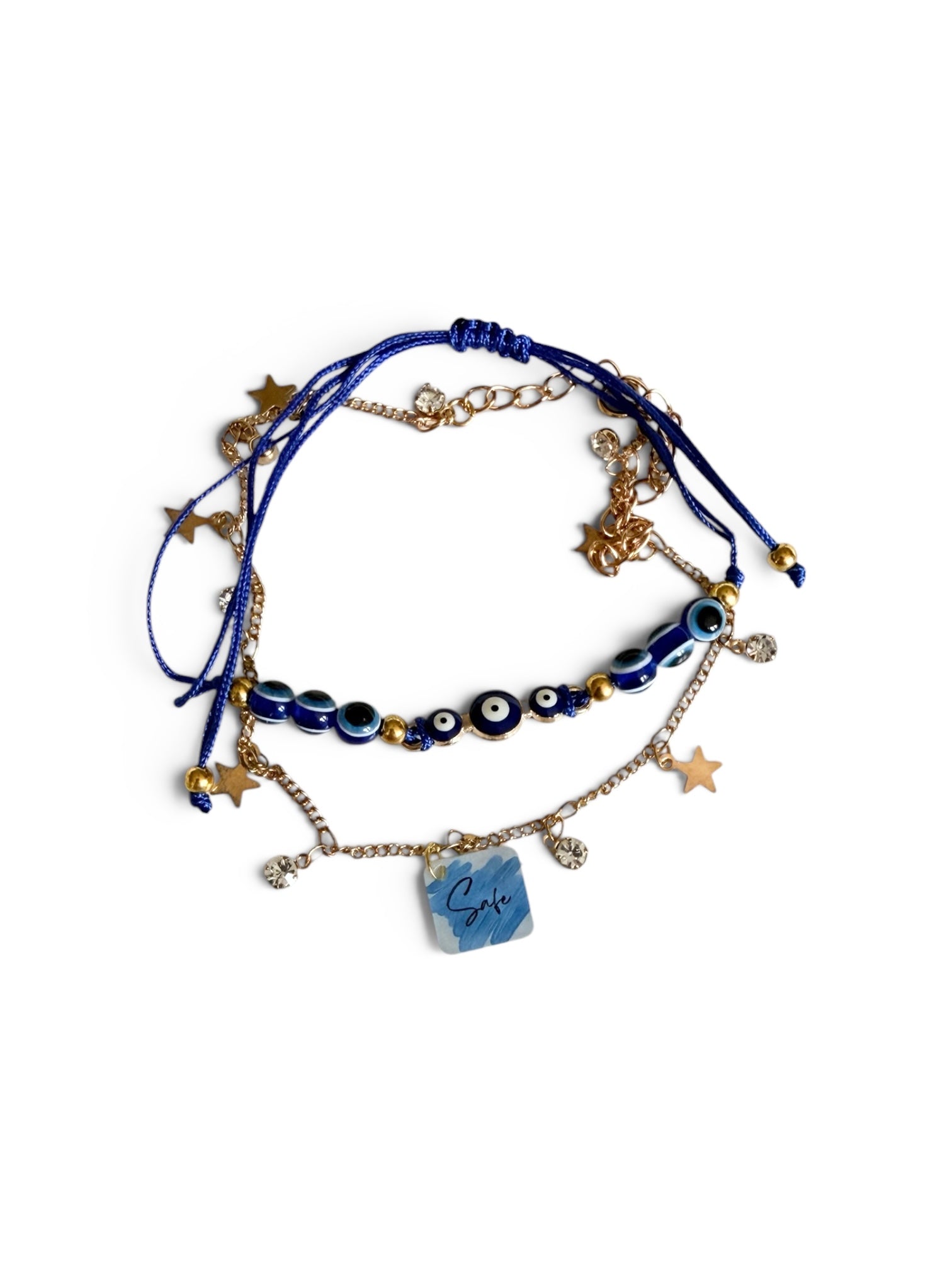 A set of two layered blue and gold anklets, featuring evil eye beads, star charms, a gold chain, and a blue marbled square charm with the word 'Safe' written on it, displayed on a clean white background.